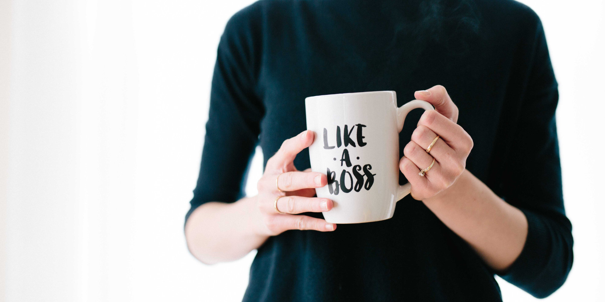 A woman holding a mug with a label saying: like a boss