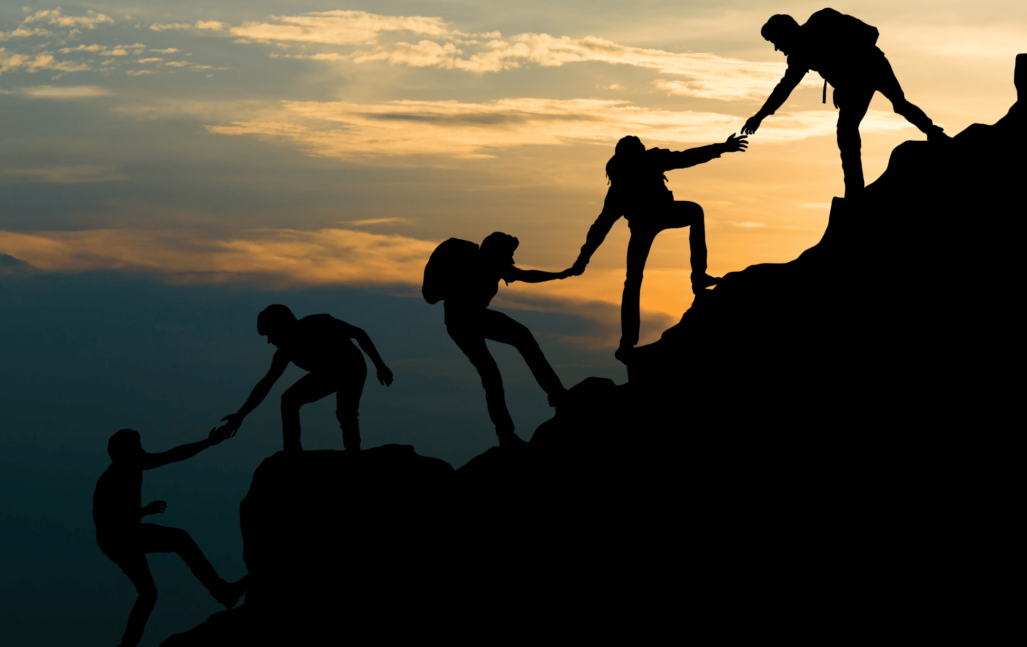People helping each other climb a steep slope, silhouetted against a
beautiful sky